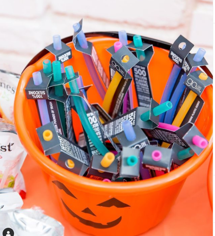 A halloween bucket filled with reusable silicone straws as treats 